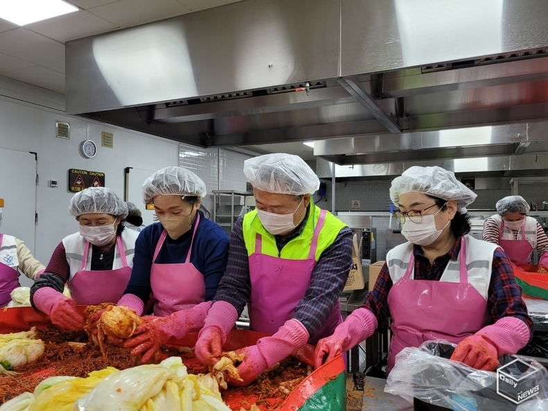 김성환 평택새마을금고 이사장(오른쪽 두번째)과 이성숙 정장선시장 사모(세번째)가 정성껏 김장을 하고 있다. 