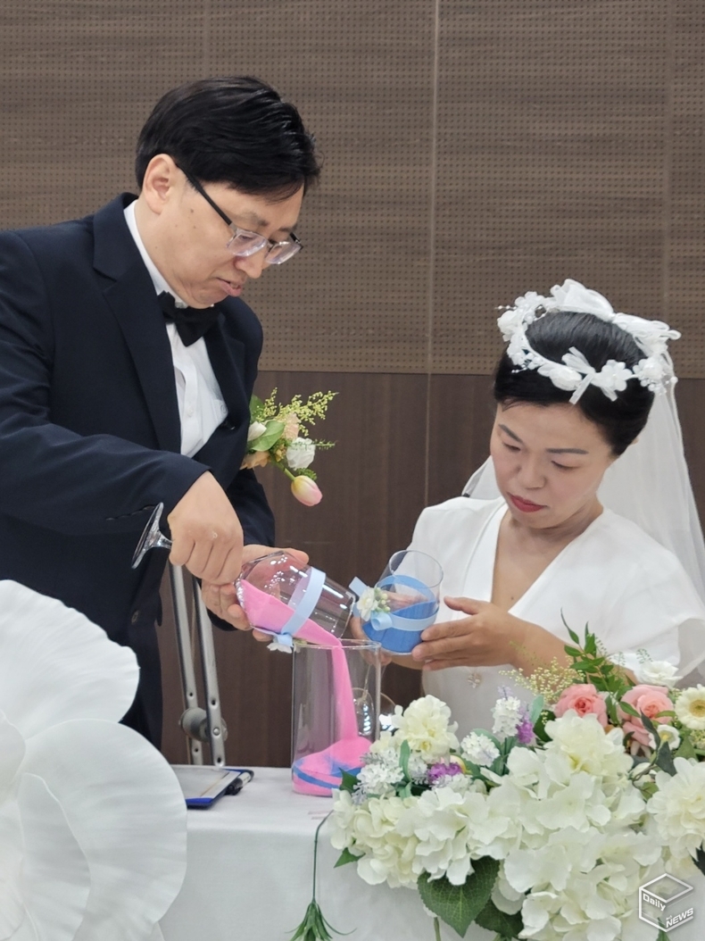 신랑 김영수(왼쪽)씨와 신부 곽해옥씨가 서로 하나되는 샌드세러머니를 하며 사랑과 행복을 다짐했다. 