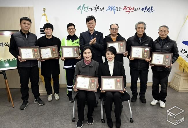 이민근 안산시장(뒷줄 가운데)이 모범시민으로 선정한 환경미화원 8명에게 표창장을 수여하고, 함께 기념촬영을 하고 있다.