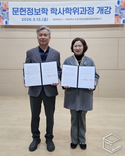 윤미영 도서관정책과장과 가천대 평생교육원 이재원 주임교수가 협약서를 들고 기념촬영을 하고 있다